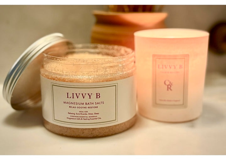 Jar of LIVVY B magnesium bath salts with a candle in the background